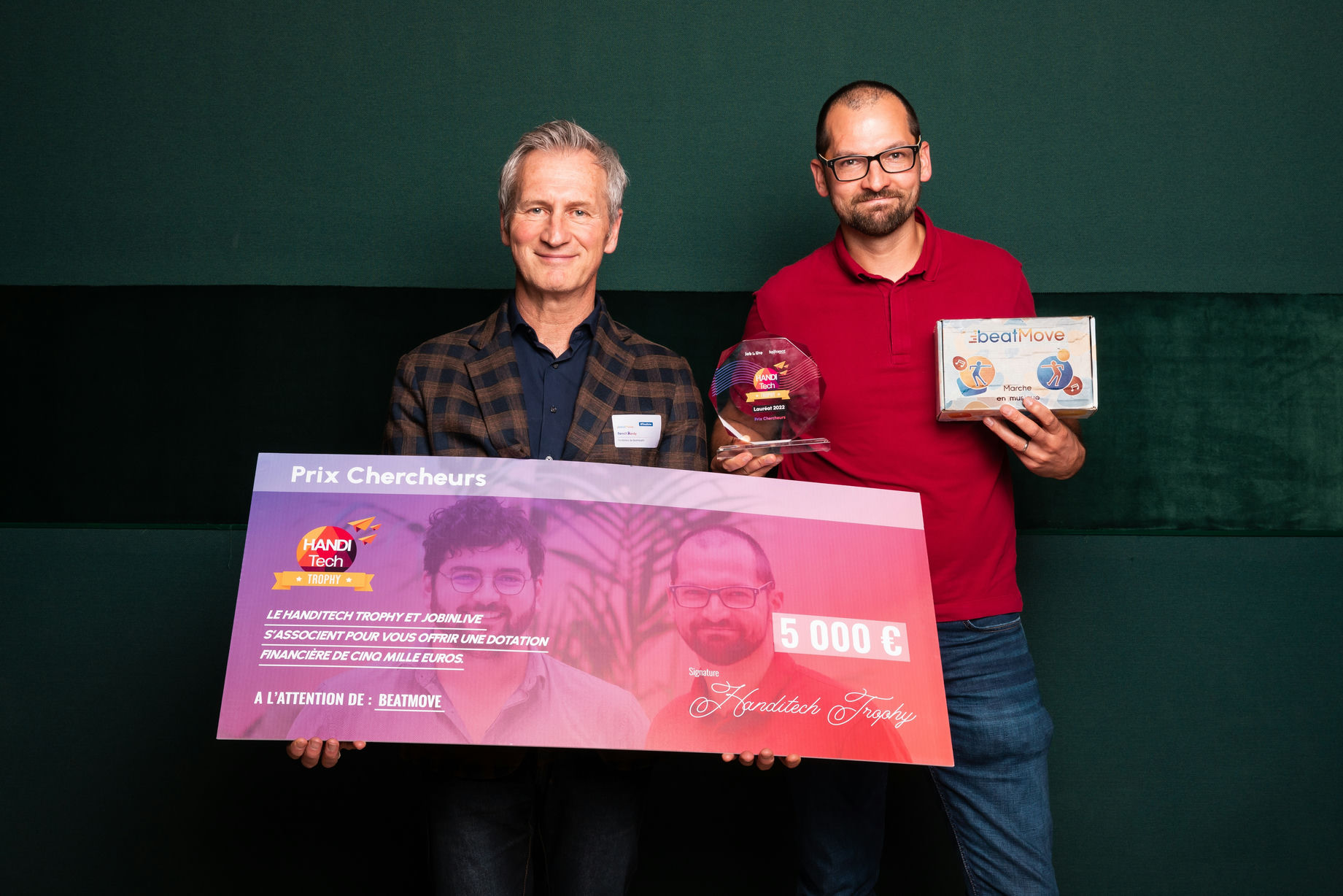 Benoit Bardy and Guillaume Tallon holding a bank check